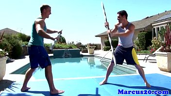 Gay muscular jocks sword fighting by the pool
