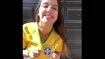 Очень горячая молодая девушка в коротких шортах, одетая в футболку сборной Бразилии