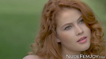 Young redhead sensually teasing in nature