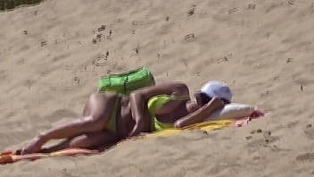 横向きのビーチで黄色いビキニの女性