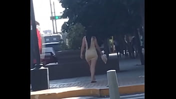 Venezuelan with a good body walking down the street in a striped dress