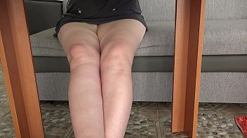 A hidden camera under the table spies on plump legs and peeks under the skirt while a mature housewife drinks tea. Amateur foot fetish.