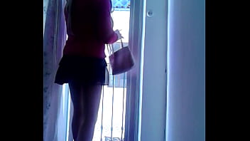 Submissive Lili cd in red heels looks out on the balcony to receive a client