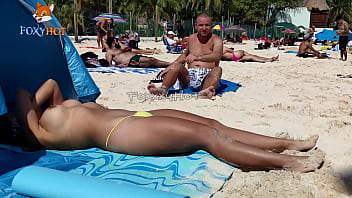 Prendere il sole in topless sulla spiaggia per essere guardati da altri uomini