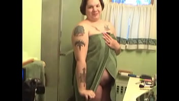Tattooed fat chick strips to wash her tits and cunt in the shower