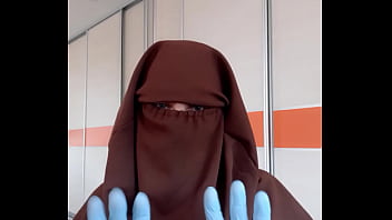 Housekeeper in apron putting on niqab