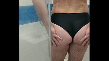 Transexual sexy vistiendo traje de baño de una pieza y masturbándose